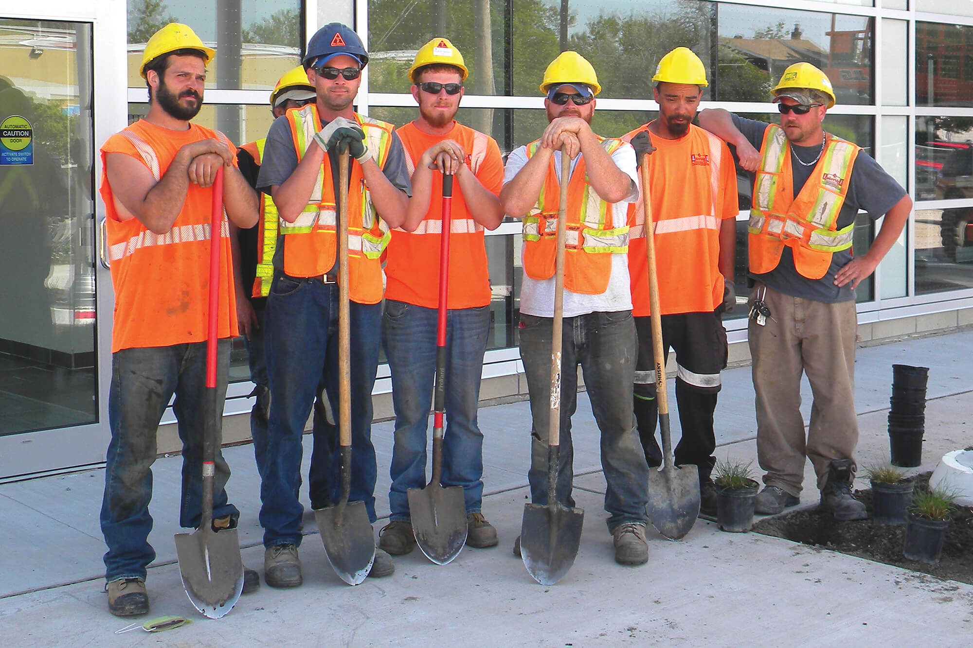 group of men in construction clothes holding shovels
