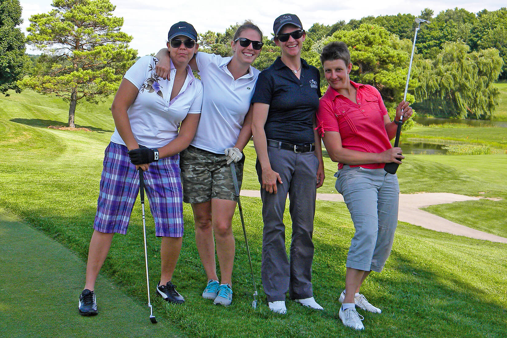 four women golfers posing on the golf course