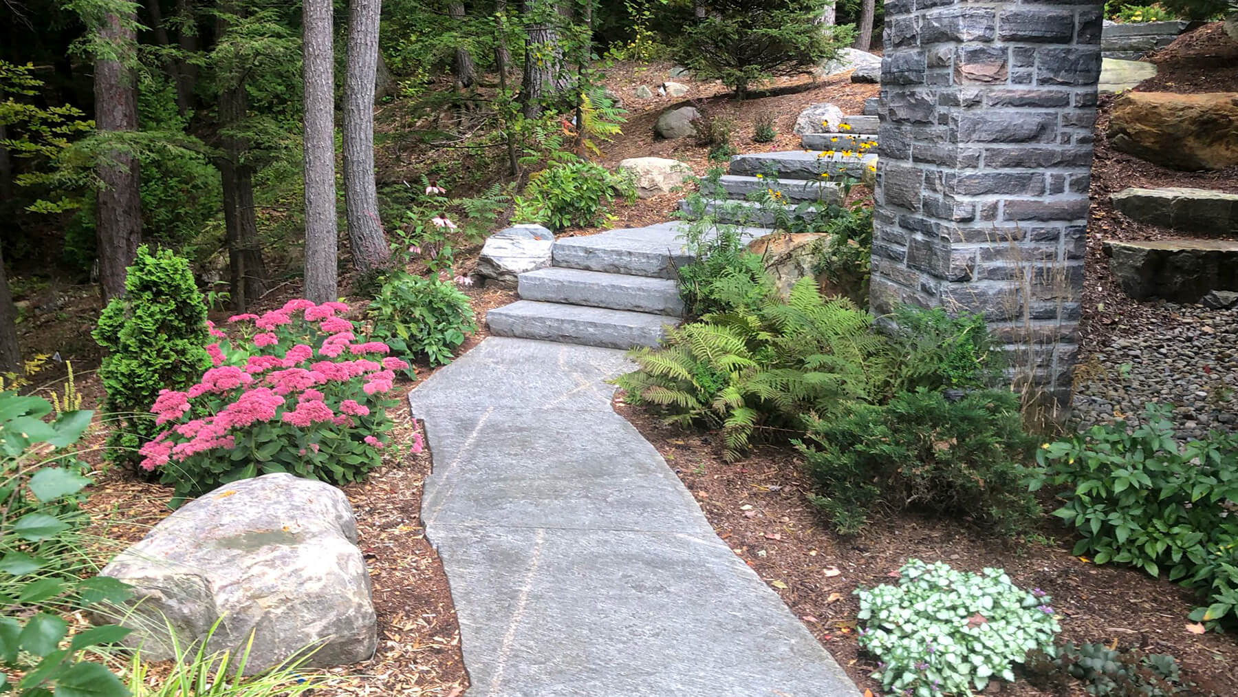 natural stone steps winding down a hill around a house