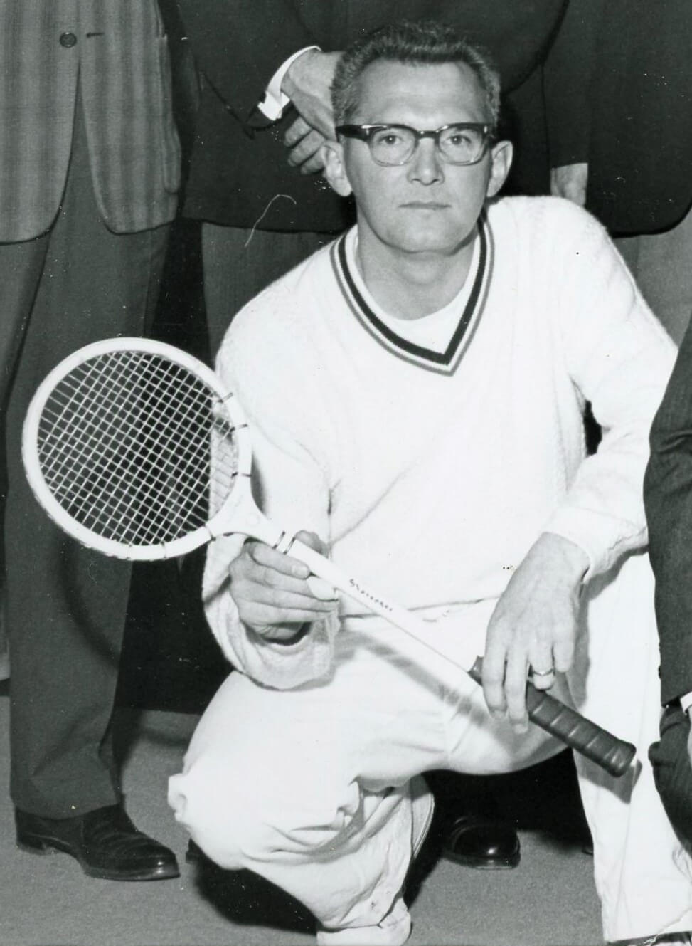old photo of a man posing with a racquet