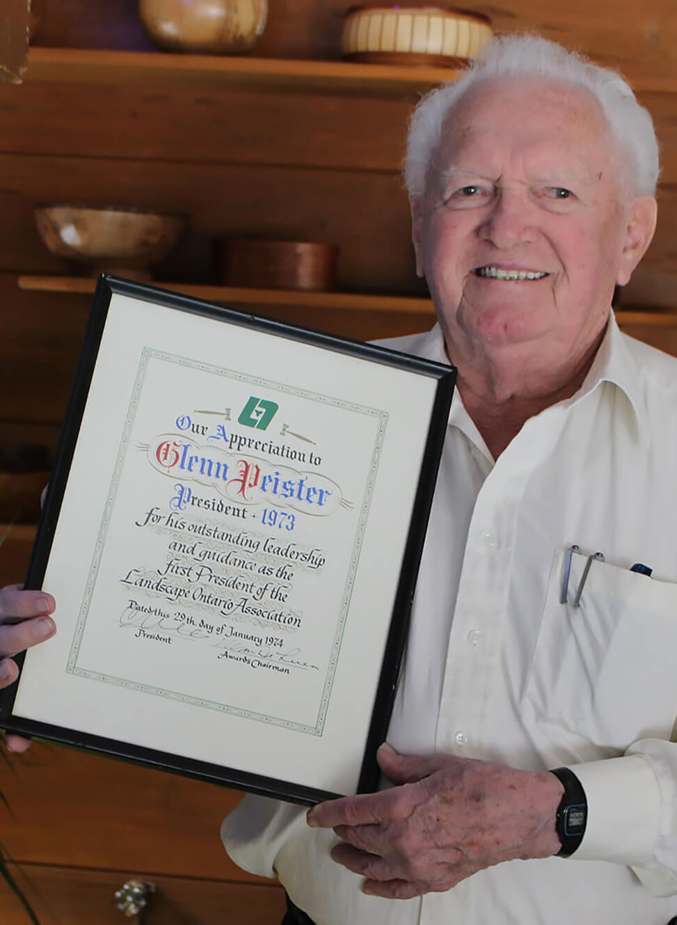 older man proudly holding a certificate