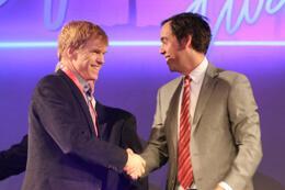 two men shaking hands on stage