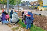 Caregivers and students look on from a safe distance as voluteers work on the property at St. Matthew's House.