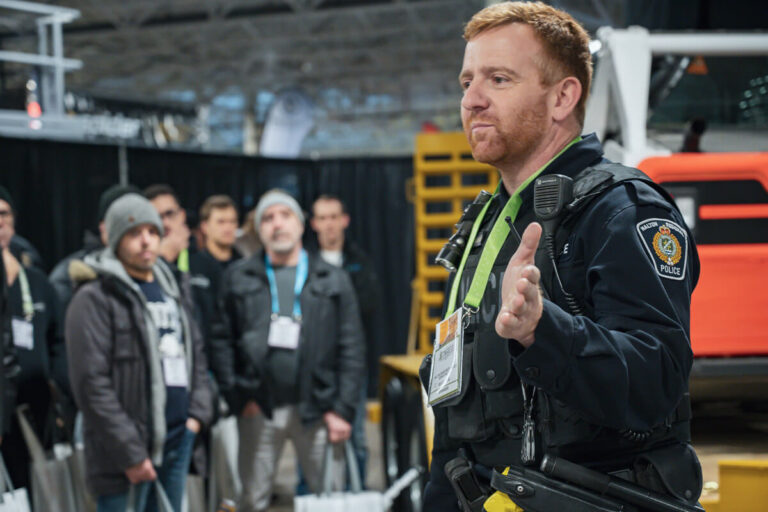 A police offer speaking to a crowd at an information session