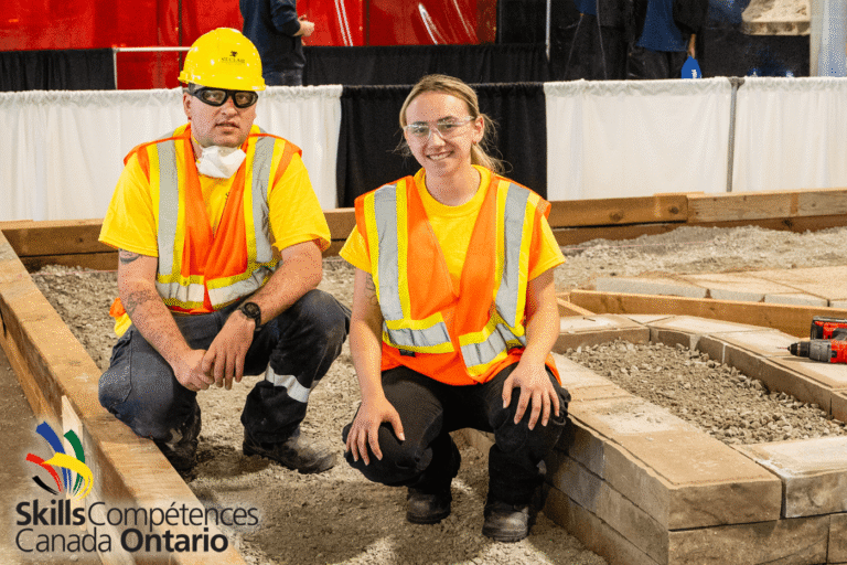 two young people in high visibility vests and safety gear