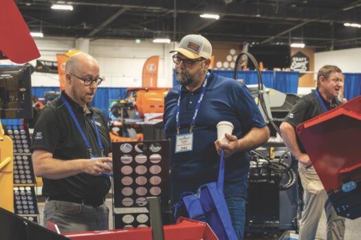 two men talking at a trade show