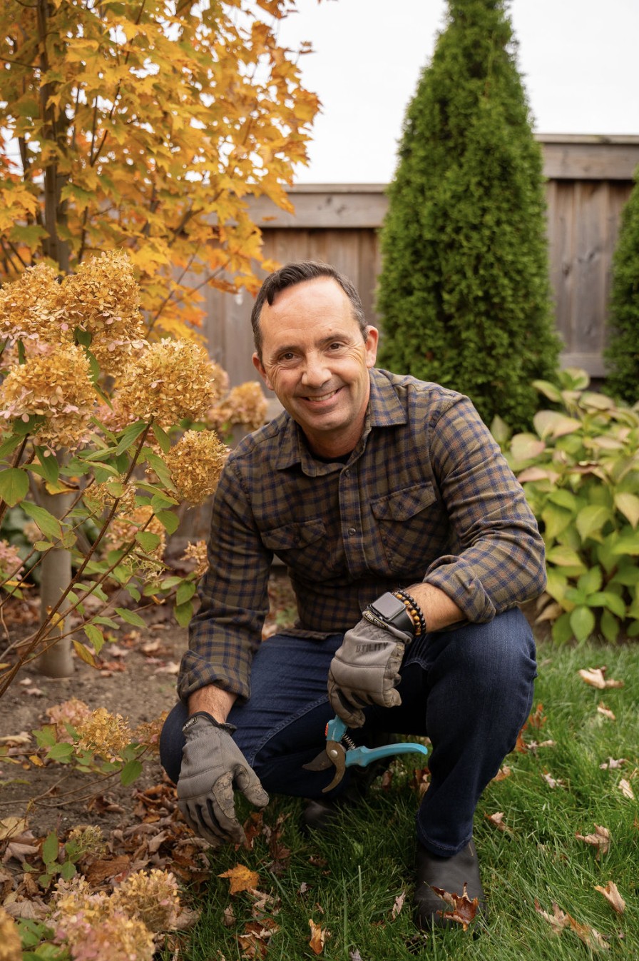 Frankie Flowers with garden and trees behind