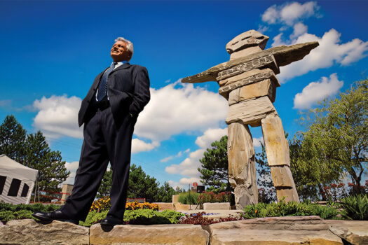 a man standing in front of a giant stone inukshuk