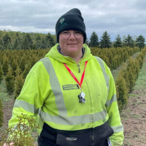 Person in a field wearing a high visibility vest and a toque